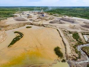 Excavator recovers material from large settling ponds used in older design of washing plants